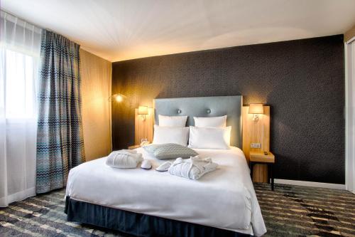 a hotel room with a bed with towels on it at Mercure Cabourg Hôtel & Spa in Cabourg