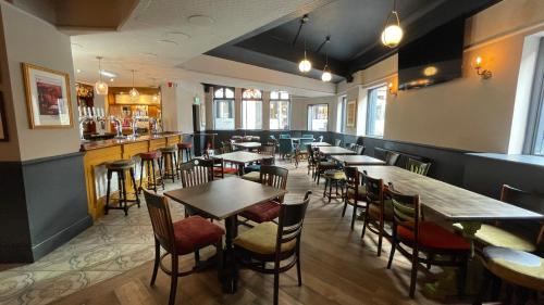 un restaurante con mesas y sillas y un bar en Piccadilly Central en Mánchester