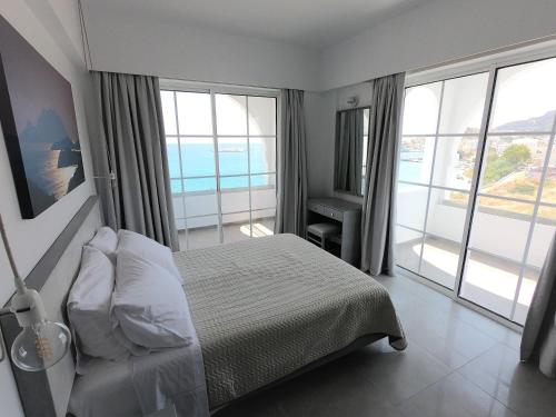 a bedroom with a bed with a view of the ocean at ALOS SUITES ex-Possirama Bay aparts in Karpathos