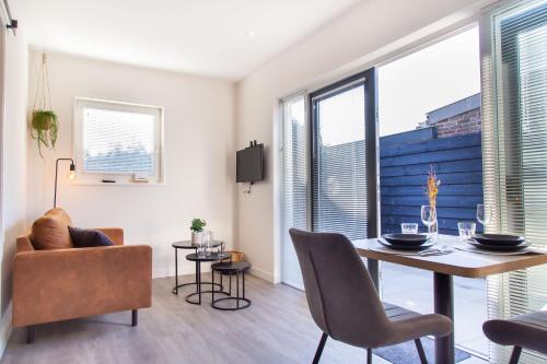 a living room with a dining room table and chairs at Vrijstaande vakantiewoning - Dicht bij het Strand in Zoutelande