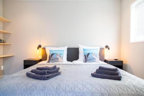 een slaapkamer met een bed met paarse handdoeken erop bij Vrijstaande vakantiewoning - Dicht bij het Strand in Zoutelande