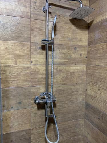 a shower with a hose attached to a wall at VIP Apartments 16 in Odesa