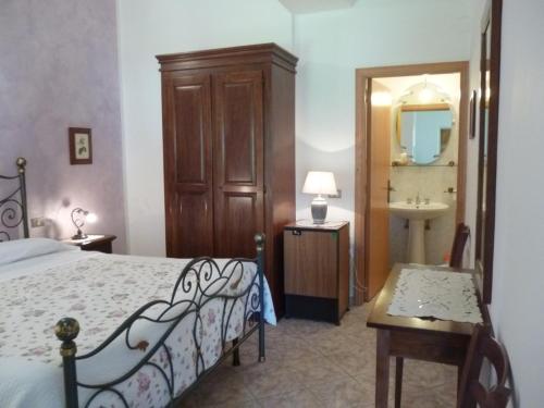 a bedroom with a bed and a bathroom with a sink at Agriturismo Le Chicche di Mafalda in Montemerano