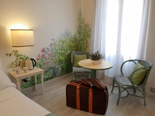 a room with a table and chairs and a suitcase at Albergo Al Moretto in Castelfranco Veneto