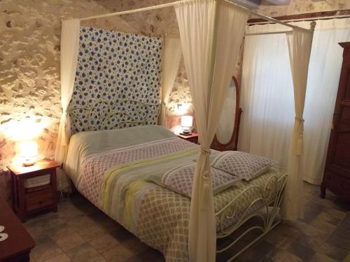 a bedroom with a bed with a canopy and two lamps at Gite de la Petite Burnie in Biras