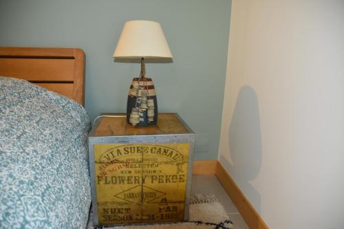 eine Lampe auf einer Schachtel neben einem Bett in der Unterkunft Sherwood in Étretat