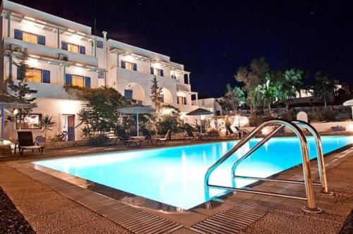 a swimming pool in front of a building at night at Caldera Romantica Hotel in Akrotiri
