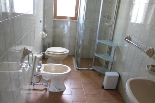 ein Bad mit einem WC, einem Waschbecken und einer Dusche in der Unterkunft appartamento petraroli by salentolimit in Porto Cesareo