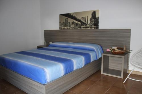 ein Schlafzimmer mit einem großen Bett mit blauer Bettwäsche in der Unterkunft appartamento petraroli by salentolimit in Porto Cesareo