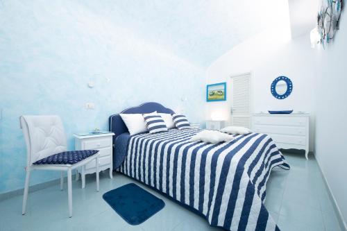 a blue and white bedroom with a bed and a chair at Atrani Apartments on the Amalfi Coast, air-purified, close to the beach and easy access in Atrani