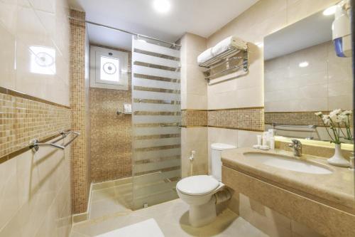 een badkamer met een toilet, een wastafel en een douche bij Tolip El Galaa Hotel Cairo in Caïro