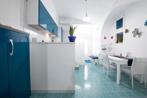 a kitchen with blue and white cabinets and a table at Atrani Apartments on the Amalfi Coast, air-purified, close to the beach and easy access in Atrani