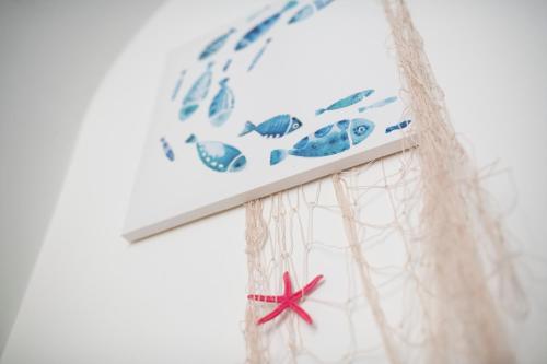 a fish sign on top of a white wall at Atrani Apartments on the Amalfi Coast, air-purified, close to the beach and easy access in Atrani