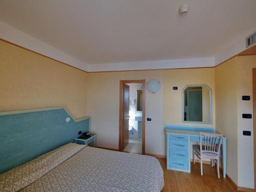 a bedroom with a bed and a desk and a chair at Hotel Residence Mondial in Moneglia