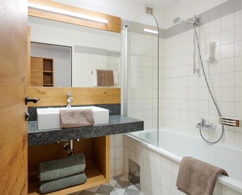 a bathroom with a sink and a tub at Landgasthof Mayr in Steyr