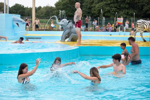 eine Gruppe von Menschen, die in einem Schwimmbad spielen in der Unterkunft Glamping Belgisch Limburg in Opglabbeek
