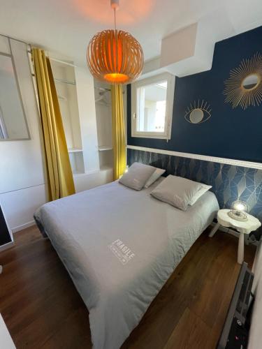 una camera da letto con un grande letto e un lampadario arancione di Gîte de la Plage a Wimereux