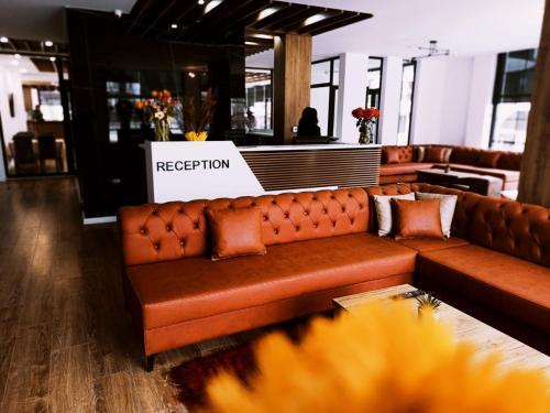 a brown leather couch in a store with a registration sign at Grand Hotel Pogradec in Pogradec