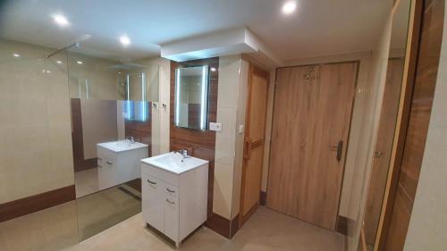 a bathroom with two sinks and a glass door at Retrohaus in Liptovský Mikuláš