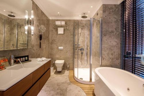 a bathroom with a tub and a toilet and a shower at Amiral Palace Hotel Boutique Class in Istanbul