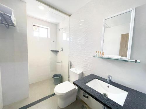 a bathroom with a toilet and a sink and a mirror at M Stays in Chennai
