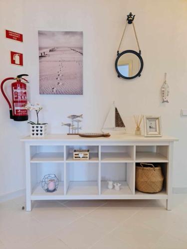 a white console table with a mirror on the wall at Albur Beach House in Alvor