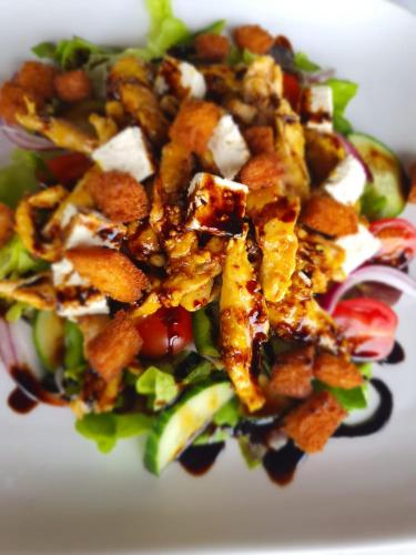 a salad with nuts and cheese on a white plate at Villa Paradiso in Hartbeespoort