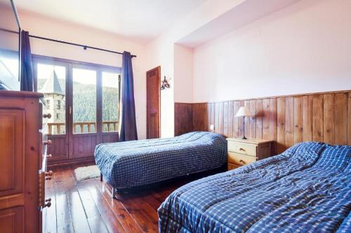 a hotel room with two beds and a window at Apartamentos Tanau in Baqueira-Beret