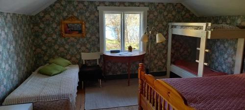 Schlafzimmer mit einem Bett, einem Schreibtisch und einem Fenster in der Unterkunft Sankt Anna Bed and Boat, in Sankt Anna