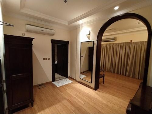 an empty room with a mirror and a wooden floor at Al Khariss Hotel in Doha