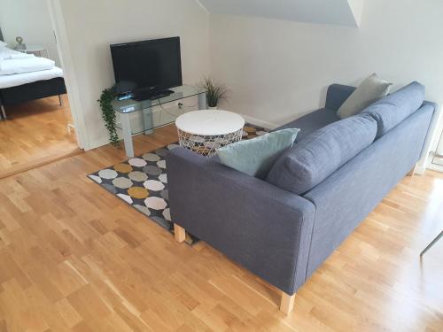 a living room with a blue couch and a table at Veversmauet Apartments in Bergen