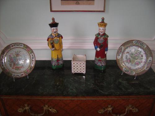 three statues on a dresser with plates on it at Chambres d'hôtes & Gîtes du Château de Grand Rullecourt in Grand Rullecourt