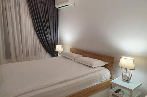 1 dormitorio con 1 cama blanca y 2 lámparas en Apartment with balcony, Lighthouse Golf Resort, 62sqm en Balchik
