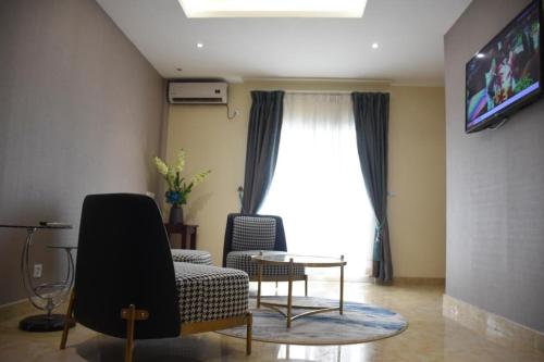 a living room with a couch and a tv at Hotel Royal Palace in Douala
