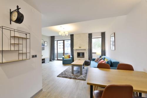 a living room with a blue couch and a table at Luxury Mountain Apartment in Poiana Brasov