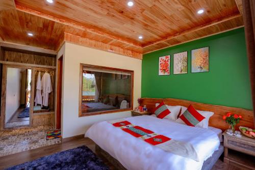 a bedroom with a large bed and a green wall at Alley House Sapa Homestay in Sa Pa