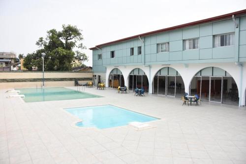 a building with a swimming pool in front of a building at Hotel Royal Palace in Douala