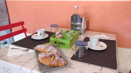 a table with a table with food and a bottle of wine at Caicai Bed And Breakfast in Saluzzo