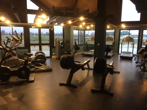 a gym with several treadmills and exercise bikes at Mercure Cabourg Hôtel & Spa in Cabourg