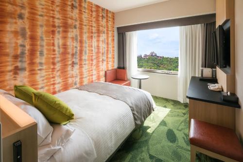 a hotel room with a bed and a window at HOTEL MYSTAYS Matsuyama in Matsuyama