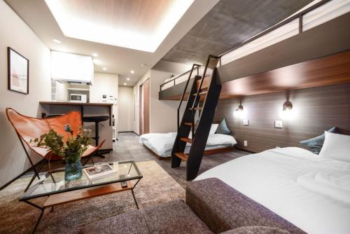 a hotel room with a bunk bed and a couch at Ken's Place Azabudai in Tokyo
