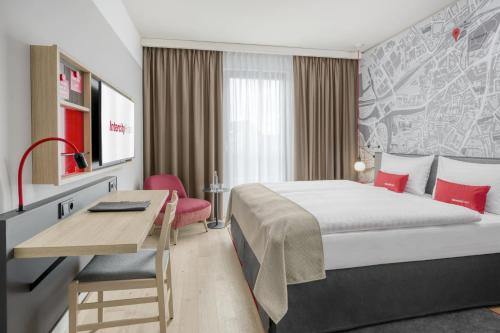 um quarto de hotel com uma cama e uma secretária em IntercityHotel Hildesheim em Hildesheim