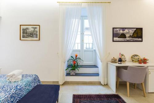 a bedroom with a bed and a desk and a window at Casetta Fuoro Guest House in Sorrento