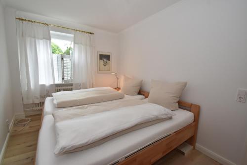 a bedroom with two beds with white sheets and a window at fewo1846 - Belvedere - behaglich ausgestattete Wohnung mit Balkon und Hafenblick in Flensburg