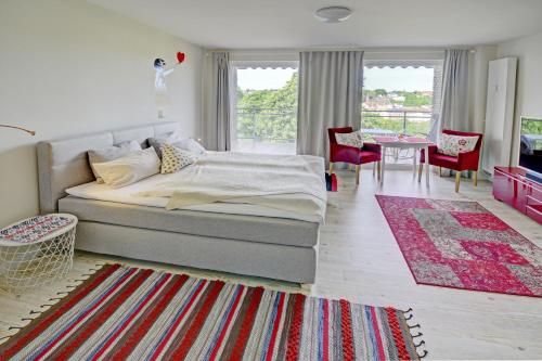 um quarto com uma cama, uma mesa e cadeiras em fewo1846 - FlensView - komfortables Studioapartment mit Balkon und Hafenblick em Flensburg