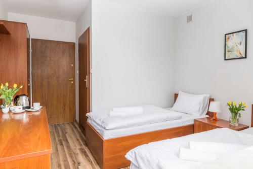 a bedroom with two beds and a wooden cabinet at EndHotel Bielany Wroclawskie in Bielany Wrocławskie