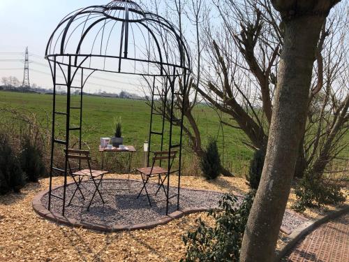 a cage with two chairs and a table in a field at Lieblingsplatz - Ferienwohnung Verse in Eddelak