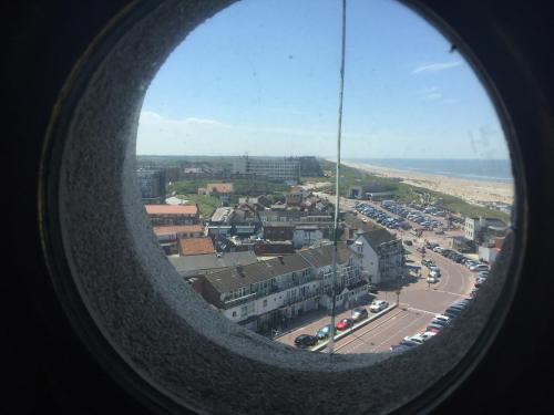 a view of a city from a round window at Torenlicht in Egmond aan Zee