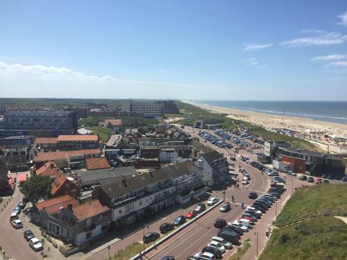 an aerial view of a city with a beach and cars at Torenlicht in Egmond aan Zee