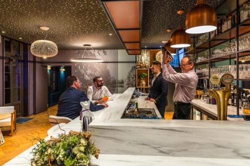 a group of men standing at a bar at Mercure Saint Omer Centre Gare in Saint-Omer